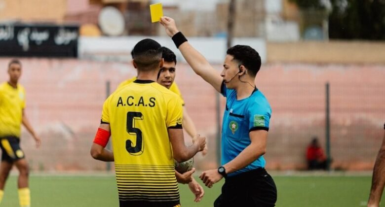 The referee shows a yellow card during a soccer game.